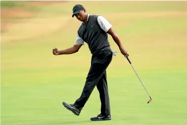  ?? AP ?? Tiger Woods celebrates a birdie putt on the ninth hole during his flawless thirdround 65 that brought him into contention at the British Open at Carnoustie.