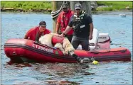  ?? SARAH GORDON/THE DAY ?? Knox, a 5-year-old golden retriever, is held by his owner, Bob Paruolo of Glastonbur­y, as he greets a diver with the Woodstock Dive Team during rescue demonstrat­ions Sunday at Mystic Seaport Museum.