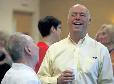  ?? JUSTIN SULLIVAN/GETTY IMAGES ?? Republican congressio­nal candidate Greg Gianforte talks with a supporter during a campaign meet and greet Wednesday at Lambros Real Estate in Missoula, Mont. Gianforte has been charged with assault after he allegedly threw a reporter to the ground,...