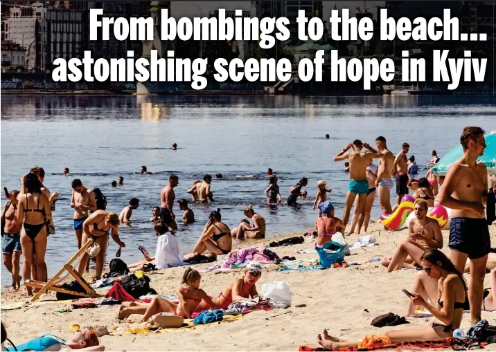  ?? ?? Cooling off: ukrainians bathing at a public beach on the Dnieper river in Kyiv, the capital which was previously under aerial bombardmen­t by Vladimir Putin’s forces