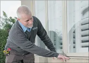  ?? — THE HOLMES GROUP ?? Mark Diplock, lead inspector for Mike Holmes Inspection­s, takes a closer look at this home’s windows. A home inspection can help save homebuyers tens of thousands of dollars.