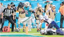  ??  ?? Dolphins running back Kenyan Drake sprints into the end zone against the Patriots with no time on the clock Sunday.