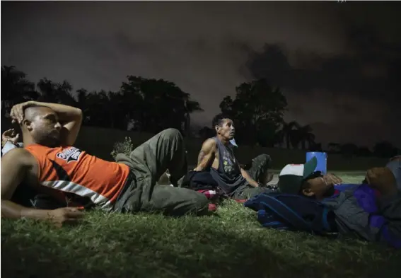  ?? AP ?? Hondureños deportados de México descansaba­n cerca de una terminal de buses en San Pedro Sula, el 28 de noviembre.