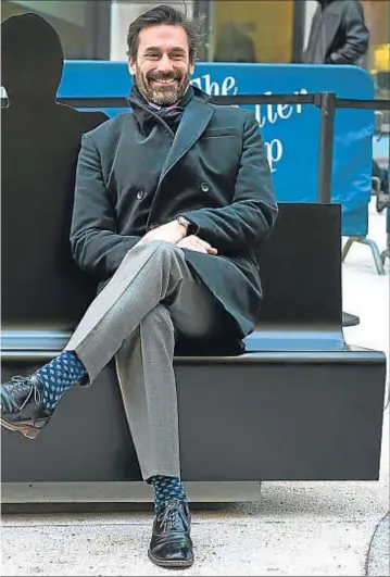  ?? TIMOTHY A. CLARY / AFP ?? Relajado. Jon Hamm posa al lado de una sombra artística de Don Draper situada en una plaza de la avenida de las Américas de Nueva York