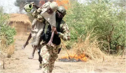  ?? Photo: NAN ?? Platoon Commander, 192 Battalion, Lt. Asajuwon Ahmadu carries an elderly man rescued during a cross fire operation between troops and Boko Haram members at Gobara area of Gwoza Local Government Area of Borno State