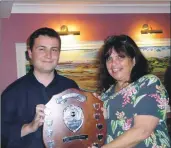  ??  ?? Morag Cupples accepts the most improved drummer shield on behalf of her son Ali, presented by lead drummer Graeme McMillan.