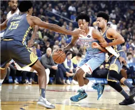  ?? AP FOTO ?? DOUBLE. Sacramento Kings’ De’Aaron Fox (5) drives past Golden State Warriors’ Damian Jones (15) and Quinn Cook.