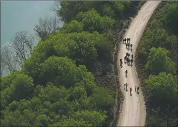  ?? (AP/Julio Cortez) ?? Migrants walk on a dirt road after crossing the U.S.-Mexico border in Mission, Texas.