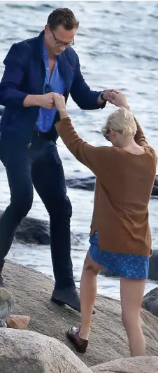  ??  ?? Step this way: Tom helps Taylor climb onto a rock at the beach in Rhode Island and luckily a photograph­er saw them