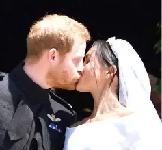  ??  ?? Prince Harry kisses his wife Meghan as they leave from the West Door of St George’s Chapel, Windsor Castle, in Windsor, on Saturday after their wedding ceremony. — AFP photos