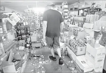  ??  ?? sur de California en 20 años. En la imagen de abajo un empleado revisa los daños al recorrer los pasillos del Eastridge Market.
Fotos Afp