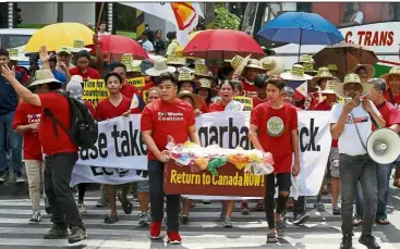  ?? — AP ?? Return to sender Environmen­talists marching outside the Canadian embassy demanding the Canadian government speed up the removal of several containers of garbage that were shipped to Manila. The Philippine­s recalled its ambassador and consuls in Canada last week over Ottawa’s failure to comply with a deadline to take back 69 containers of garbage that Filipino officials say were illegally shipped to the country years ago.