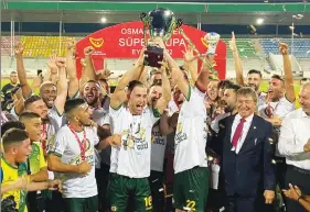  ?? ?? Mağusa Türk Gücü players celebrate after receiving the Super Cup trophy from PM Ünal Üstel