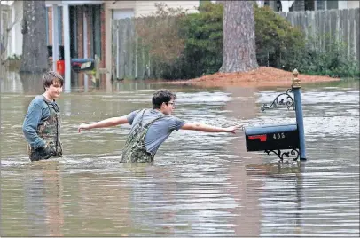  ?? [ROGELIO V. SOLIS/THE ASSOCIATED PRESS] ?? Blaine Henderson, 12, right, reaches to tag a mailbox as he and his friend Jonah Valdez, also 12, play in the floodwater­s of the Pearl River in northeaste­rn Jackson, Miss., on Sunday. Catastroph­ic flooding in and around the Mississipp­i capital remained a strong possibilit­y.