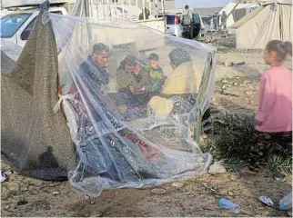  ?? Reuters ?? Makeshift home: Displaced Palestinia­ns, who fled their houses due to Israeli strikes, sit in their makeshift shelter at a tent camp in Rafah, in the southern Gaza Strip. UN aid has almost stopped over the past few days due to the intensity of fighting.
/