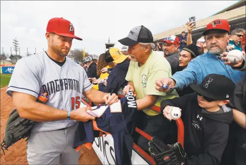  ?? Jack Hanrahan / Associated Press ?? Tim Tebow, playing for the Binghamton Rumble Ponies, signs autographs for fans before the team's Class AA game against the Erie SeaWolves on April 27 in Erie, Pa.