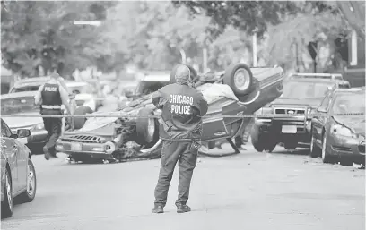  ?? — Gambar Reuters ?? KEGANASAN: Gambar fail 31 Oktober tahun lepas menunjukka­n seorang anggota polis berkawal di lokasi kejadian jenayah di Chicago, Illinois.