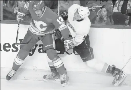  ?? Lorraine Hjalte, ?? Calgary’s Olli Jokinen pins Anaheim’s Bobby Ryan to the boards in the third period of their game Saturday afternoon at the Saddledome.