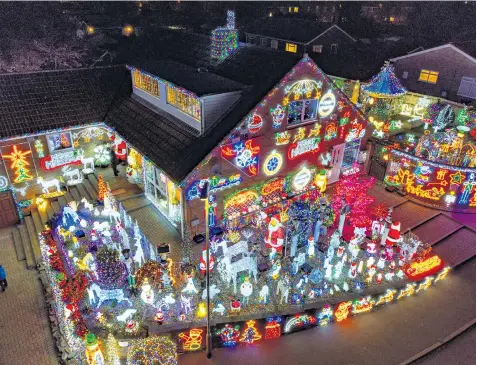  ?? ?? Helen and John Attlesey have decorated their home and garden in Soham again this year, but campaigner­s have said such festive displays have a cost on the planet