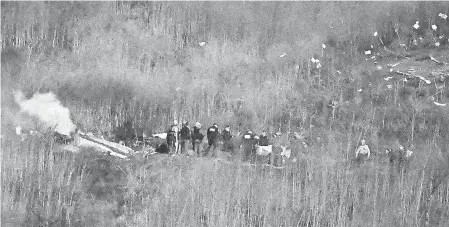  ?? KELVIN KUO/ AP ?? A body is carried from the scene of a helicopter crash that killed Bryant, his daughter and several others in Calabasas, Calif.