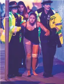  ?? Joel Goodman / London News Pictures ?? Officials assist one of the scores of people injured by the bomb blast at a concert in the north of England.