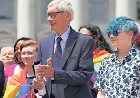  ?? MARK HOFFMAN/AP ?? Wisconsin Gov. Tony Evers, left in foreground, stands next to Aspen Morris, 16, at the gay pride flag raising event Wednesday in Madison, Wis.