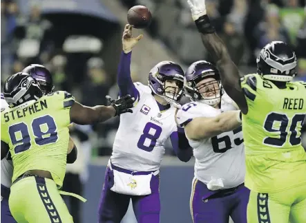  ?? STEPHEN BRASHEAR/THE ASSOCIATED PRESS ?? Vikings quarterbac­k Kirk Cousins delivers a pass while under pressure from onrushing Seahawks defenders during Monday night’s contest in Seattle. The Seahawks won 21-7.
