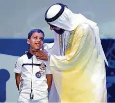  ?? WAM ?? Shaikh Mohammad congratula­tes seven year-old Mohammad Farah Jalood from Algeria, the winner of the Arab Reading Challenge’s first edition. The second-grader travelled over 30 hours to attend the awards ceremony.