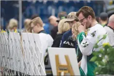  ?? Canadian Press photo ?? Mourners attend a vigil Sunday at the Elgar Petersen Arena, home of the Humboldt Broncos, to honour the victims of a fatal bus accident.