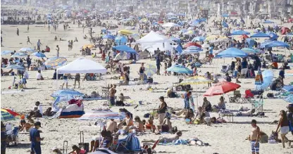  ??  ?? Visitors gather in Newport Beach, California on Sunday amid the coronaviru­s pandemic. AP