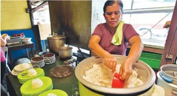  ?? MACKY LIM ?? HALF RICE ORDINANCE. A fastfood helper in Magallanes Street, Davao City prepares a cup of rice as government employees troop to their store for lunch. Last Tuesday the Davao City Council passed an ordinance requiring the food service industry to...