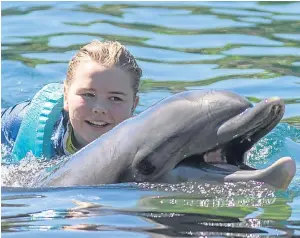  ?? Picture: PA. ?? Morgan Maxwell swims with a dolphin.