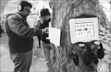  ??  ?? Indian visitors listen to audio books at the Delhi World Book fair at Pragati Maidan in New Delhi. — AFP photo