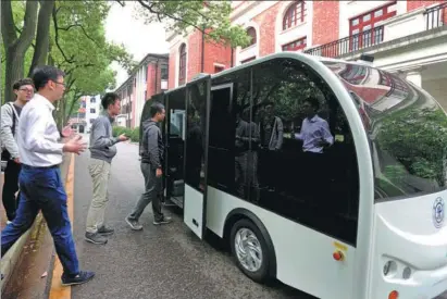  ?? LIU YING / XINHUA ?? A driverless shuttle bus on the campus of Shanghai Jiao Tong University uses AI to navigate and can carry eight passengers at a time.