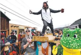  ??  ?? From left: Reed McCoy, Micah Farfour and Zach Gilula participat­e in the coffin parade during Frozen Dead Guy Days on March 11 in Nederland. Jeremy Papasso, Daily Camera