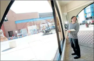  ?? JASON BAIN/EXAMINER ?? Artist John Climenhage sketches to prepare for painting a window at Peterborou­gh Square at Water and Simcoe streets as part of BLINK, an exhibition of storefront­s that will be transforme­d into works of art as part of Artsweek 2015, on Tuesday in...