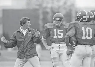  ?? AP PHOTO ?? University of Alabama football coach Ray Perkins explains techniques to his quarterbac­ks during a spring practice on March 23, 1983, in Tuscaloosa, Ala. Perkins, a former Crimson Tide star receiver who returned to Alabama as Bear Bryant’s successor that season and led the team for four years, died Wednesday. Perkins, who coached in the NFL before and after his time leading Alabama, was 79.