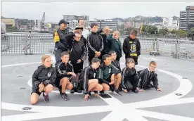  ??  ?? The children pose on the deck of the HMS Wellington.