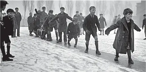  ??  ?? The slippery slope: Playground skaters in short trousers at Nightingal­e School, Hornsey, North London in 1931