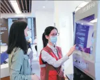  ?? PHOTOS BY ZHENG XIAOBIN / FOR CHINA DAILY ?? From top: A picturesqu­e bird’s-eye view of Xiang’an in Xiamen, Fujian province. A staff member introduces e-services to a resident in Xiang’an.