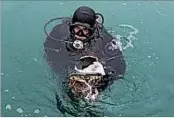  ?? VIKTOR KLYUSHIN/AP ?? A Russian diver lifts an aircraft fragment Tuesday from the Black Sea where a jet carrying 92 people crashed Sunday.