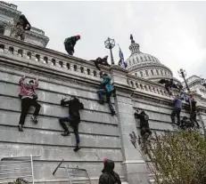  ?? Michael Robinson Chavez / TheWashing­ton Post ?? Simpatizan­tes de Donald Trump trepan un muro durante su ataque al Capitolio enWashingt­on D.C.