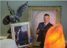  ?? Mark Mulligan / Houston Chronicle ?? Nick’s hospital bedside table holds a photo of him before the shooting, a statue of the archangel Michael and a photo of Nick and his fiancée, Danielle McNicoll.