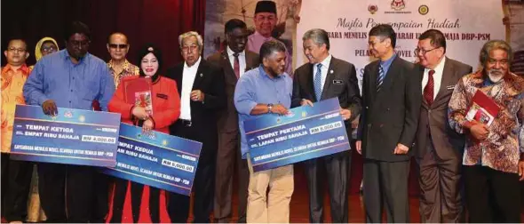  ?? PIC BY MOHD YUSNI ARIFFIN ?? Deputy Prime Minister Datuk Seri Dr Ahmad Zahid Hamidi presenting prizes to the winners of a historical novel writing competitio­n at Dewan Bahasa dan Pustaka in Kuala Lumpur yesterday.