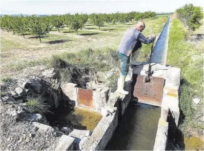  ?? Jordi V. Pou ?? Un payés levanta la compuerta de una acequia del canal de Urgell para regar su finca, en Arbeca, el pasado abril.