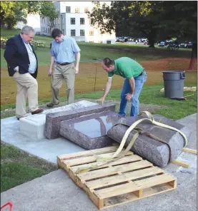  ?? Special to the Arkansas Democrat-Gazette/JEFF MITCHELL ?? Secretary of State staff members pick up pieces of the 10 Commandmen­ts monument Wednesday on the State Capitol grounds after it was toppled before dawn.