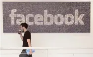  ?? FILE ?? In this March 15, 2013, file photo, a Facebook employee walks past a sign at Facebook headquarte­rs in Menlo Park, California. The San Jose Mercury News reports Saturday, March 17, 2018 that building permits compiled by Buildzoom show Facebook plans to...