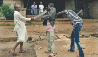  ?? PICTURE: AP ?? TENSE STAND-OFF: Muslim men with machetes accost a Christian man while checking him for weapons in the Miskine neighbourh­ood of Bangui, Central African Republic, yesterday.