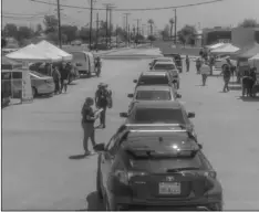  ?? PHOTO VINCENT OSUNA ?? Representa­tives from the approximat­ely 23 agencies in attendance distribute items to vehicles in line during a drive-thru health fair and food distributi­on event on Thursday.