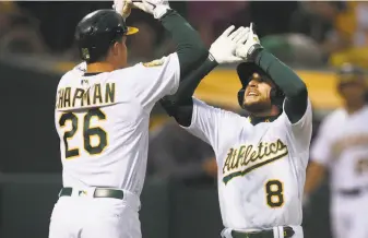  ?? Ben Margot / Associated Press ?? Jed Lowrie (8) celebrates with Matt Chapman after hitting a two-run homer off the Mariners’ Felix Hernandez in the third to put the A’s ahead 3-1. They led the rest of the way.